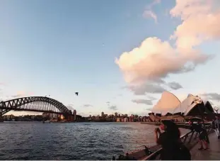  ??  ?? SYDNEY: Photo shows tourists taking pictures during sunset over Sydney’s iconic landmark Opera House. —AFP