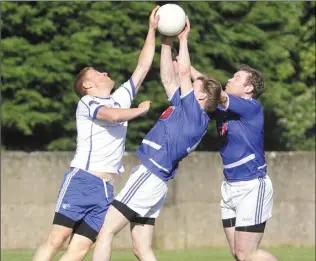  ??  ?? Alan Murphy of Lannleire, along with Harry O’Connell and Ciaran Savage of Roche Emmets reach for the ball during the Group C JFC match in Louth Village.