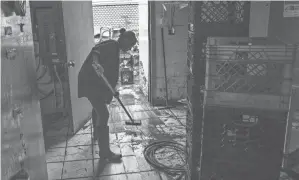  ?? EDUARDO MUNOZ ALVAREZ/AP ?? A worker cleans at Four Boys Ice Cream store during the passing of Tropical Storm Henri in Jamesburg, N.J., on Monday.