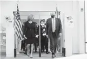  ?? EVAN VUCCI/AP ?? President Donald Trump walks into the main library inWest Palm Beach withWendy Sartory Link, Palm Beach County’s supervisor of elections, after casting his ballot Saturday.