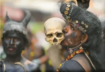  ?? RAJESH KUMAR SINGH/AP ?? Happy anniversar­y: A Hindu devotee of Lord Shiva holds a human skull in his teeth as he takes part in a procession Saturday during the Maha Shivaratri festival in Prayagraj, in the northern Indian state of Uttar Pradesh. Hindus observe Shivaratri, or the Night of Shiva, annually on a moonless night to celebrate the anniversar­y of the marriage of Shiva.