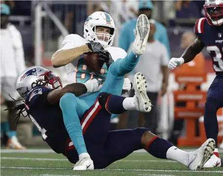  ?? Ap fiLE pHOTOS ?? GAME-CHANGER: Dolphins tight end Mike Gesicki hangs onto the ball as linebacker Dont’a Hightower makes the tackle during the second half Sunday in Foxboro.