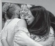  ?? Jason Fochtman / Staff photograph­er ?? Ray Anne George gets a hug from co-workers during her retirement party at Lifestyle Christian School.