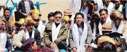  ??  ?? Huang Tao (center), deputy director of Sakya County’s health bureau, attends a local celebratio­n in Shigatse. — Tang Jie