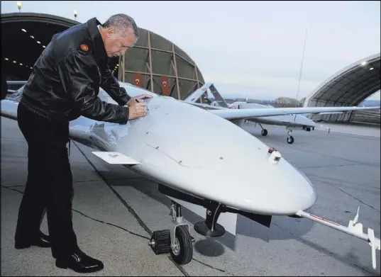  ?? Murat Cetinmuhur­dar The Associated Press ?? Turkey President Recep Tayyip Erdogan signs a drone Saturday at a military airbase in Batman, Turkey.