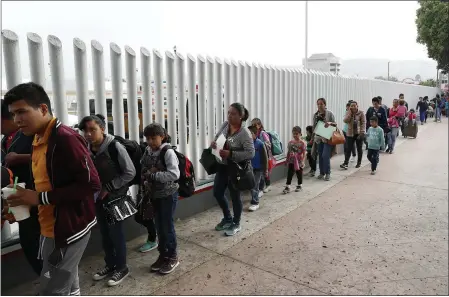  ?? GREGORY BULL — THE ASSOCIATED PRESS FILE ?? People line up to cross into the United States to begin the process of applying for asylum near the San Ysidro port of entry in Tijuana, Mexico.