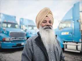  ?? COLE BURSTON THE CANADIAN PRESS ?? Nachhattar Chohan, president of CH Expedite, stands among a few of his trucks in Mississaug­a.