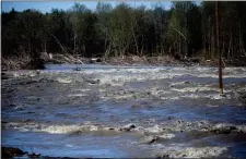  ?? JAKE MAY — THE ASSOCIATED PRESS ?? Water rushes through the path where the Edenville Dam once stood on Wednesday north of Midland, Mich.