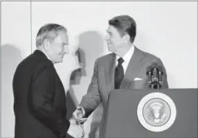  ?? IRA SCHWARZ — THE ASSOCIATED PRESS FILE ?? In this file photo, David Rockefelle­r, left, chairman of the Council Americas, shakes hands with President Ronald Reagan at the State Department in Washington. David Rockefelle­r, the billionair­e philanthro­pist who was the last of his generation in the...