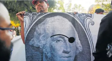  ??  ?? Save the jobs: A union worker holds a banner during a protest on Sunday against Nafta negotiatio­ns outside where the fifth round of the trade talks involving the US, Mexico and Canada is taking place in Mexico City, Mexico.