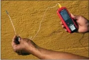  ?? ASSOCIATED PRESS FILE PHOTO ?? Vivek Shandas, a professor of climate adaptation at Portland State University, takes a temperatur­e reading of almost 106degrees in downtown Portland, Ore., on Aug. 12.