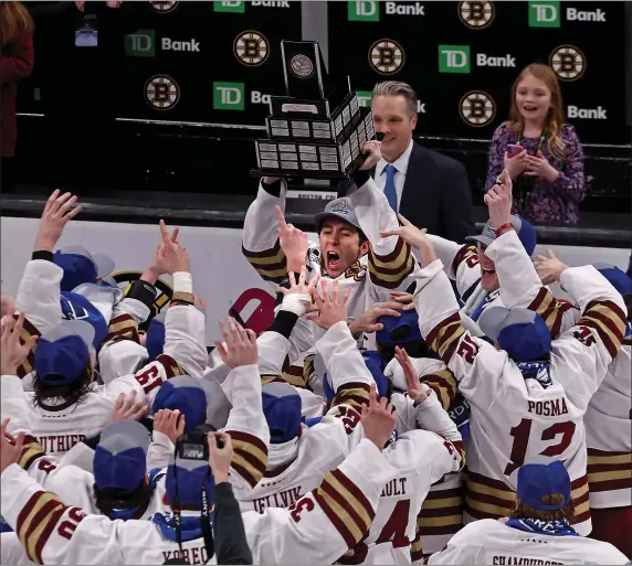  ?? (STAFF PHOTO — STUART CAHILL/BOSTON HERALD ?? Boston College defenseman Eamon Powell (2) holds the trophy after the Eagles skated past rival BU, 6-2, to capture the Hockey East championsh­ip Saturday night at the TD Garden.