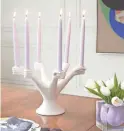  ?? JONATHAN ADLER ?? Designer Jonathan Adler pays homage to Paris’ Pompidou Center with a candelabra he calls Eve; a ringlet of white porcelain hands stands ready to grip tapers, like a circle of dancers.