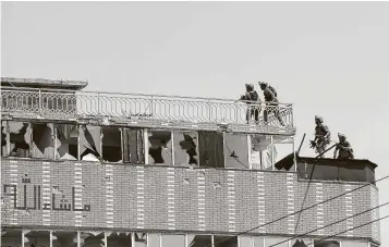  ?? Rahmat Gul / Associated Press ?? Afghan troops take positions on a prison building Monday in the city of Jalalabad, east of Kabul, Afghanista­n. An attack to free ISIS and Taliban prisoners killed at least 29 people.