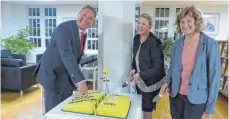  ?? FOTO: ADDICKS ?? Ralf Sorg schneidet die Torte an, Susanne Irion (links) und Ingrid Bauser warten auf die ersten Stücke.