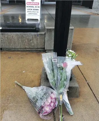  ?? NICK PROCAYLO ?? A flower memorial marks the entrance to Abbotsford Senior Secondary School following last Tuesday’s fatal stabbing of student Letisha Reimer. Reimer’s friend was also injured in the attack.