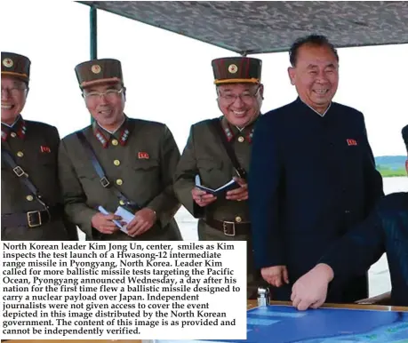  ??  ?? North Korean leader Kim Jong Un, center, smiles as Kim inspects the test launch of a Hwasong-12 intermedia­te range missile in Pyongyang, North Korea. Leader Kim called for more ballistic missile tests targeting the Pacific Ocean, Pyongyang announced...