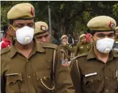  ?? — AFP ?? Security personnel wear masks as they patrol on a road in New Delhi on Friday.