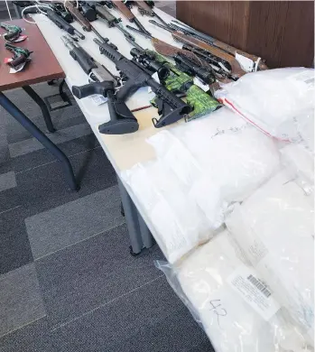  ?? JONATHAN HAYWARD/THE CANADIAN PRESS ?? Drugs and firearms at the RCMP headquarte­rs in Surrey on Wednesday. More than 100 kg of drugs, two boats and 15 firearms were seized in a U.S.-Canada internatio­nal effort.