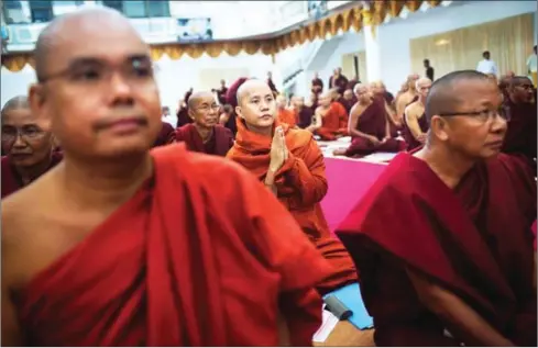  ?? ADAM DEAN/THE NEW YORK TIMES ?? Ashin Wirathu (centre) the leader of the nationalis­t Buddhist group Ma Ba Tha, prays with fellow monks in Hmawbi, Myanmar, on June 12, 2013. Under his leadership, Ma Ba Tha has been accused of promoting violence against Muslims.