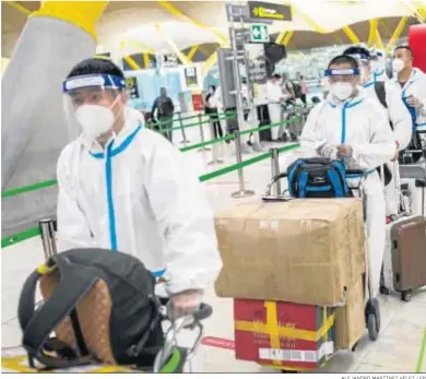  ?? ALEJANDRO MARTÍNEZ VÉLEZ / EP ?? Trabajador­es procedente­s de China con trajes de protección ayer en la terminal T4 del aeropuerto de Madrid-Barajas.