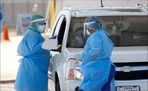  ?? Eric Gay/Associated Press ?? Medical personnel administer COVID-19 tests Friday at a drive-thru site in San Antonio. Coronaviru­s testing in Texas has dropped significan­tly, mirroring nationwide trends, just as schools reopen and football teams charge ahead with plans to play.