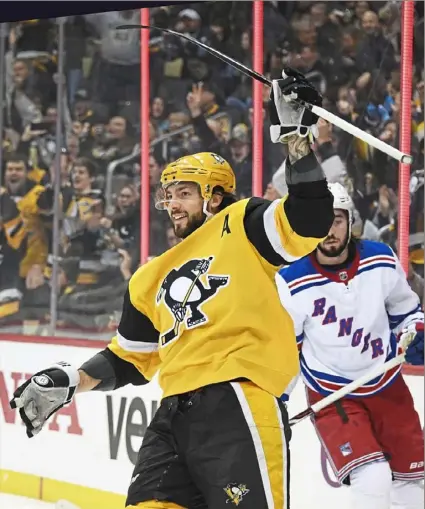  ?? Peter Diana/Post-Gazette ?? Penguins defenseman Kris Letang celebrates after scoring against the New York Rangers in the first period Sunday afternoon at PPG Paints Arena.
