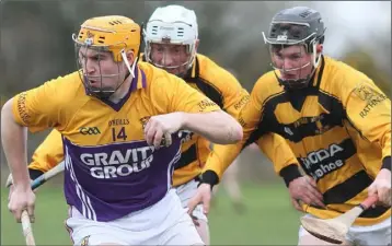  ??  ?? Rhys Clarke of Faythe Harriers tries t o evade Rathnure’s Paddy Whiteley and Brian Quigley.