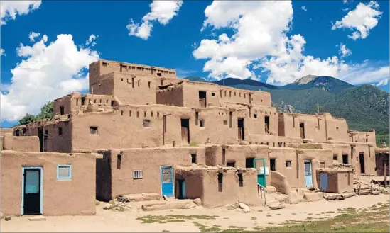  ?? PHAS UIG via Getty Images ?? TAOS PUEBLO, north of Taos, N.M., is a UNESCO World Heritage site by the Sangre de Cristo Mountains. Witnessing its cemetery is a moving experience.