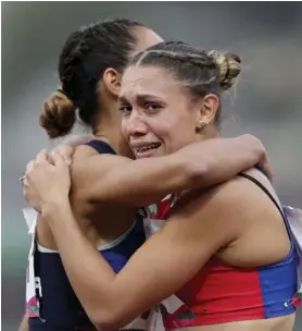  ?? AP ?? La campeona panamerica­na celebra su triunfo con una corredora no identifica­da, momentos después de concluir la carrera.