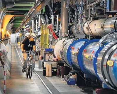  ?? FABRICE COFFRINI / AFP ?? Un trabajador del LHC recorre el túnel en bicicleta