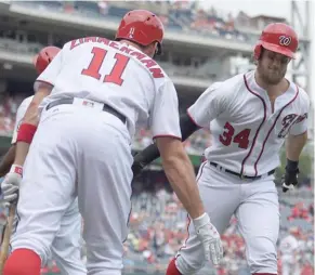  ?? Wass, AP) (Photo by Nick ?? Washington Nationals' Bryce Harper (34) celebrates his two-run home run with Ryan Zimmerman (11) during the first inning of Thursday's game in Washington.