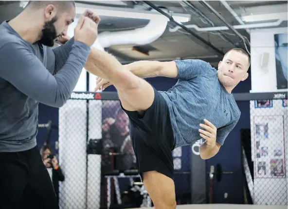  ?? — JOHN MAHONEY FILES ?? Georges St-Pierre, already considered one of the greatest fighters of all time, spars with trainer Firaz Zahabi as he prepares to return to the Octagon after four years on the sidelines. If he can’t shake off the rust, Saturday could be a long night...