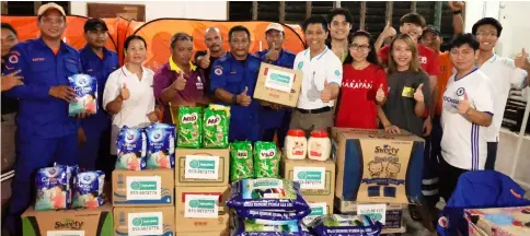  ??  ?? Sim (front, third right) and Wan on her right join Bomba and APMM personnel, as well as Hope Place volunteers in distributi­ng food items and diapers to the flood victims at Dewan Serajak Tringgus.