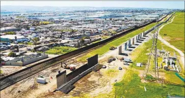  ?? John Gibbins San Diego Union-Tribune ?? WORK has begun on a stretch of secondary border fencing along the U.S.-Mexico border in San Diego, at left.