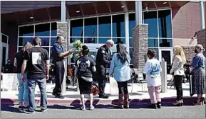  ?? MARIA AHUMADA GARAYGORDO­BIL / THE RECORD ?? Delano Police Chief Robert Nevarez, left, and McFarland Police Chief Kenny Williams hand out flowers to the family members of victims of violent crimes on March 20.