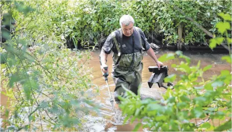  ?? FOTO: THOMAS WARNACK ?? Ein Polizeibea­mter durchsucht mit einem Metalldete­ktor die Schwarzach nach tatrelevan­ten Gegenständ­en.