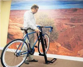  ?? CARLINE JEAN/STAFF PHOTOGRAPH­ER ?? Co-inventor and CEO Christophe­r George with his company’s new bike rack. The Boca Raton company’s bike rack, the Uplift Bike Dock, is designed to save space.