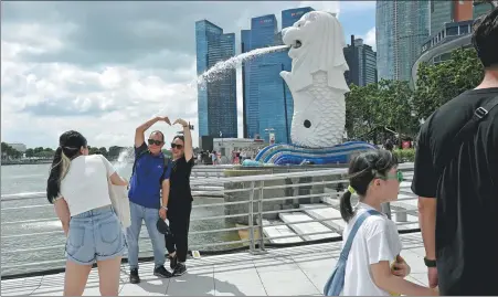  ?? XINHUA ?? Tourists visit the Merlion Park in Singapore on Dec 21. The mutual visa-exemption agreement between China and Singapore, effective from Feb 9, is set to further boost people-to-people exchanges.