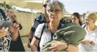  ?? (Facebook) ?? LESLEY SACHS is seen at the Kotel yesterday being detained with her Torah scroll.