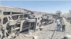  ?? AFP ?? People gather around the wreckage of two trains that collided in the Tahta district of Sohag province killing at least 32 people last month.