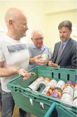 ?? Picture: Kris Miller. ?? Bruce Adamson, right, children and young people’s commission­er for Scotland, talking to staff and volunteers Huw Stansfield and Peter Andrews at Dundee Foodbank.