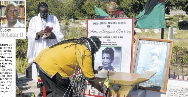  ?? ?? Claude “Big Stone” Sinclair places a Jamaican flag on the grave of the late Amy Euphema Jacques Garvey following a memorial service held at St Andrew Parish Church in Half-way-tree on December 31, 2022. Looking on is Rev Fr Bertram Gayle (left).