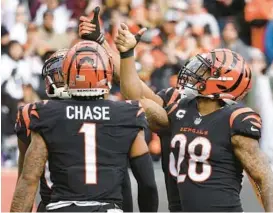  ?? KIRK IRWIN/GETTY PHOTOS ?? Bengals running back Joe Mixon, right, celebrates his touchdown by flipping a coin during Sunday’s game against the Ravens in Cincinnati.