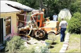 ?? COURTESY BENTON COUNTY ?? Workers remove a street sweeper that crashed into a home near Monte Ne on June 6, pinning a woman and her infant son underneath it. The woman, Teresa Ruiz, remains in a Springfiel­d, Mo., hospital with multiple injuries. Her son wasn’t seriously injured.