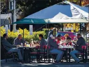  ??  ?? Outdoor diners enjoy lunch in the parking lot at Jeffrey’s Hamburgers on Thursday in Menlo Park. Some Bay Area residents under stay-at-home orders are heading to San Mateo County, where the strictest coronaviru­s restrictio­ns have yet to be ordered.