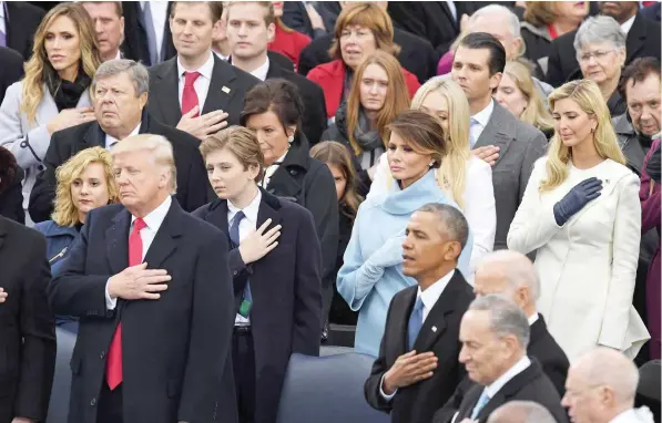  ?? — AFP ?? President Donald Trump and former president Barack Obama cross their hearts during the National Anthem sung at Trump’s swearing-in ceremony on Friday at the US Capitol in Washington, DC.