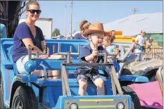 ?? CAROLE MORRIS-UNDERHILL ?? William Patriquin, 2, from Middle Sackville, acts as a chauffeur as mother, Amy Nichols, accompanie­s him on one of the rides at the Hants County Exhibition Sept. 15.