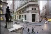  ?? MARK LENNIHAN — THE ASSOCIATED PRESS FILE ?? People walk to work on Wall Street beneath a statue of George Washington, in New York. U.S. stock indexes finished Tuesday close to where they started as technology companies and household goods makers rose.