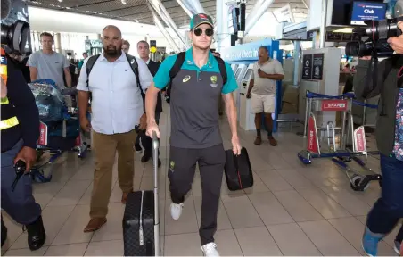  ?? PICTURE: AP ?? SCANDAL: Australian cricket captain Steve Smith, centre, with teammates, at the Cape Town Internatio­nal airport as they depart to Johannesbu­rg for the final five-day Test match.